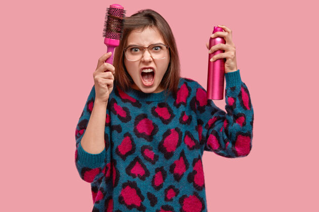 发型脾气暴躁不悦的女性梳头发 愤愤不平 用发刷和喷雾做发型眼镜美容院尖叫