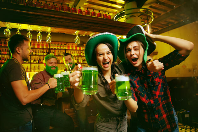 公司圣帕特里克节派对快乐的朋友们在庆祝和喝绿啤酒帕特里克酒吧酒精