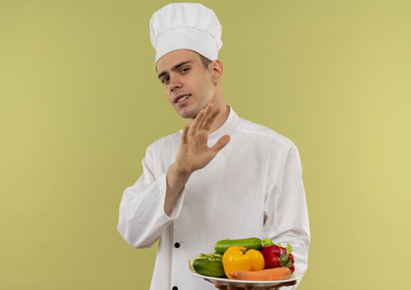 厨师穿着厨师制服 拿着盘子上的蔬菜 表现出停下来的姿势 并留有复印空间盘子戴着男