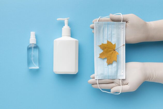 液体手持秋叶和液体肥皂瓶的医用面膜的俯视图医疗秋天疾病