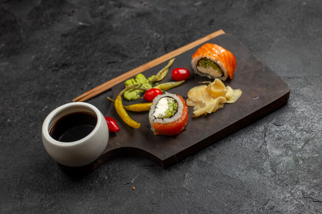 美味灰色墙壁上美味的寿司餐鱼片卷的正面视图盘子切片菜肴