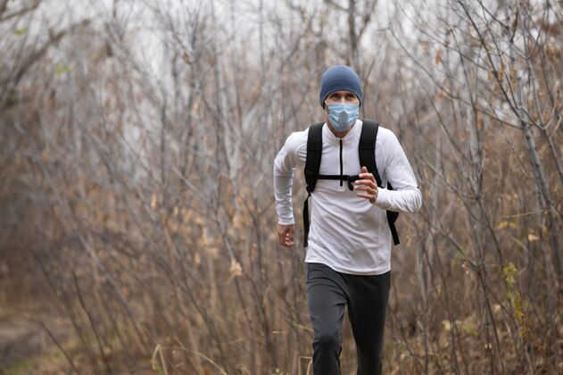 跑步戴着面具的人在树林里跑水平训练运动